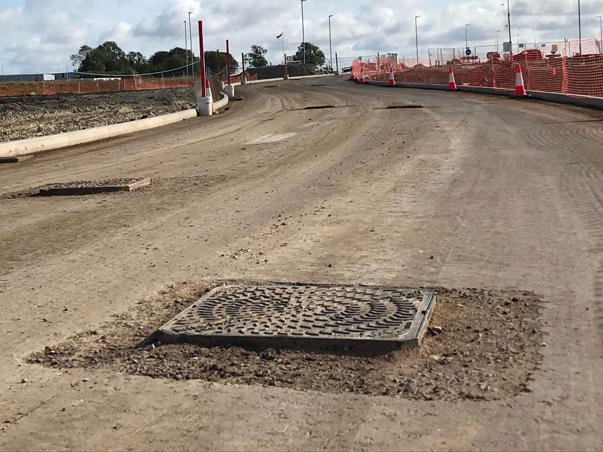 Manhole cover installed proud of the binding layer