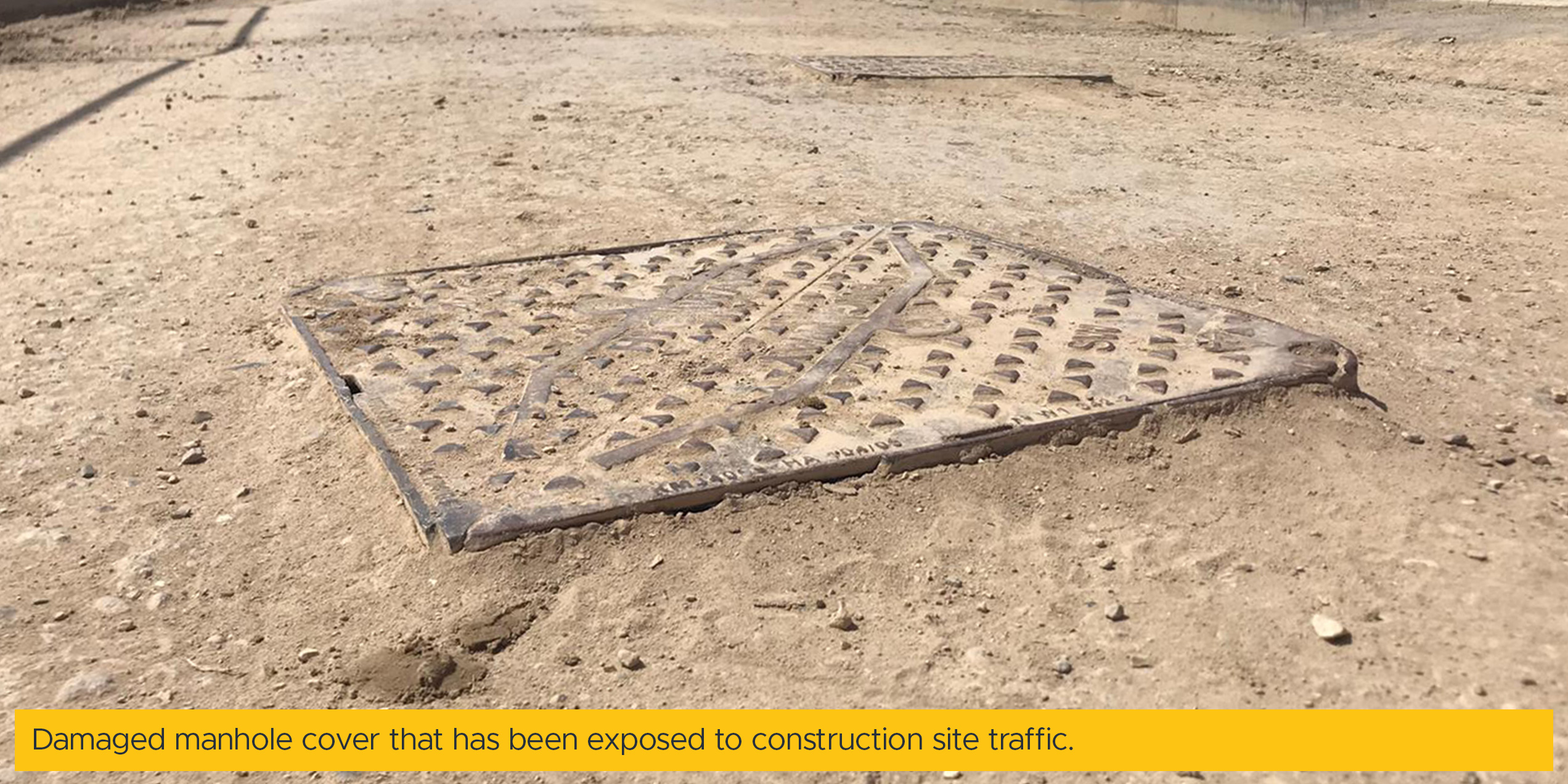 Damaged manhole cover that has been exposed to construction site traffic