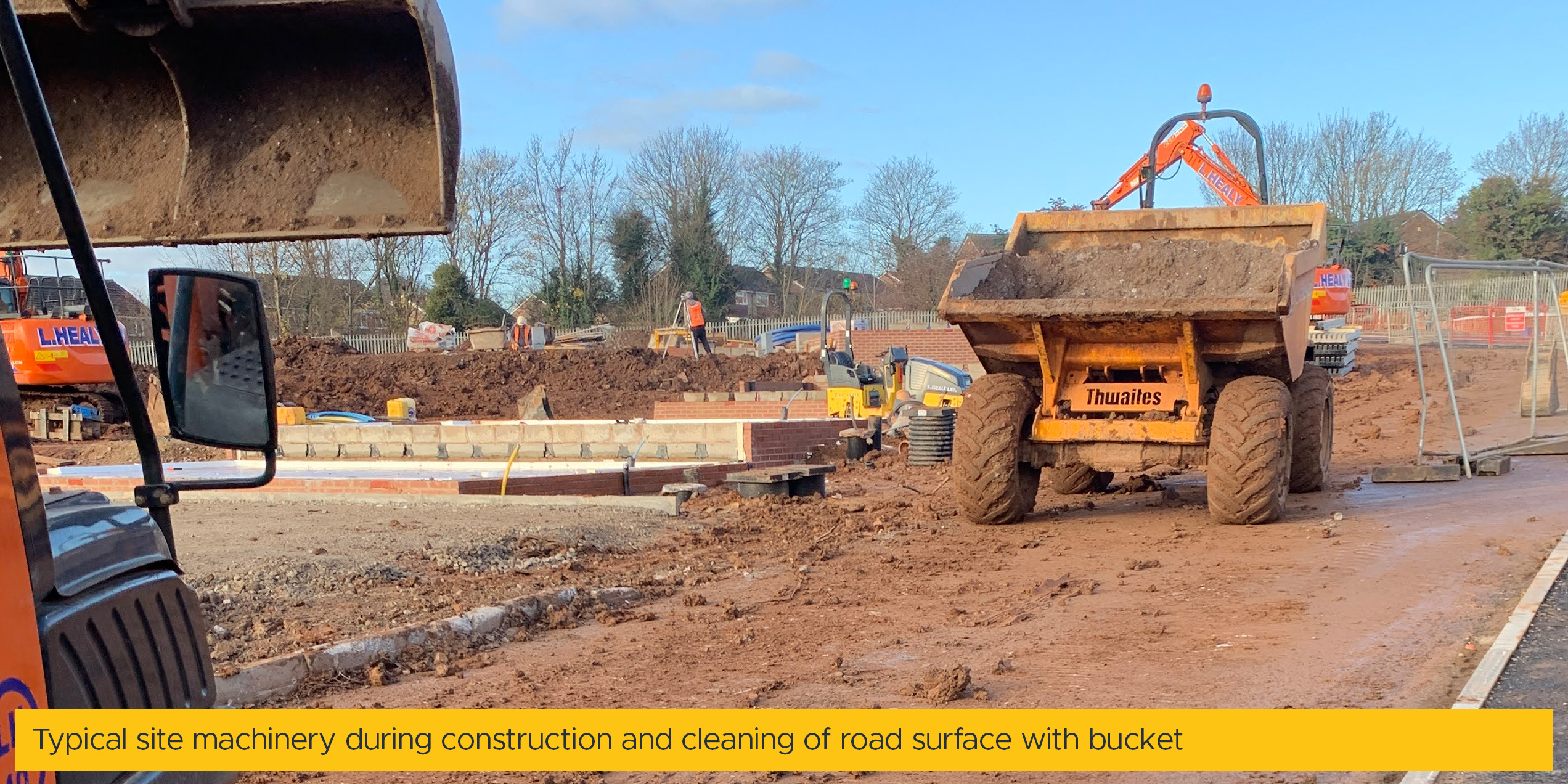 Typical site machinery during construction and cleaning of road surface with bucket