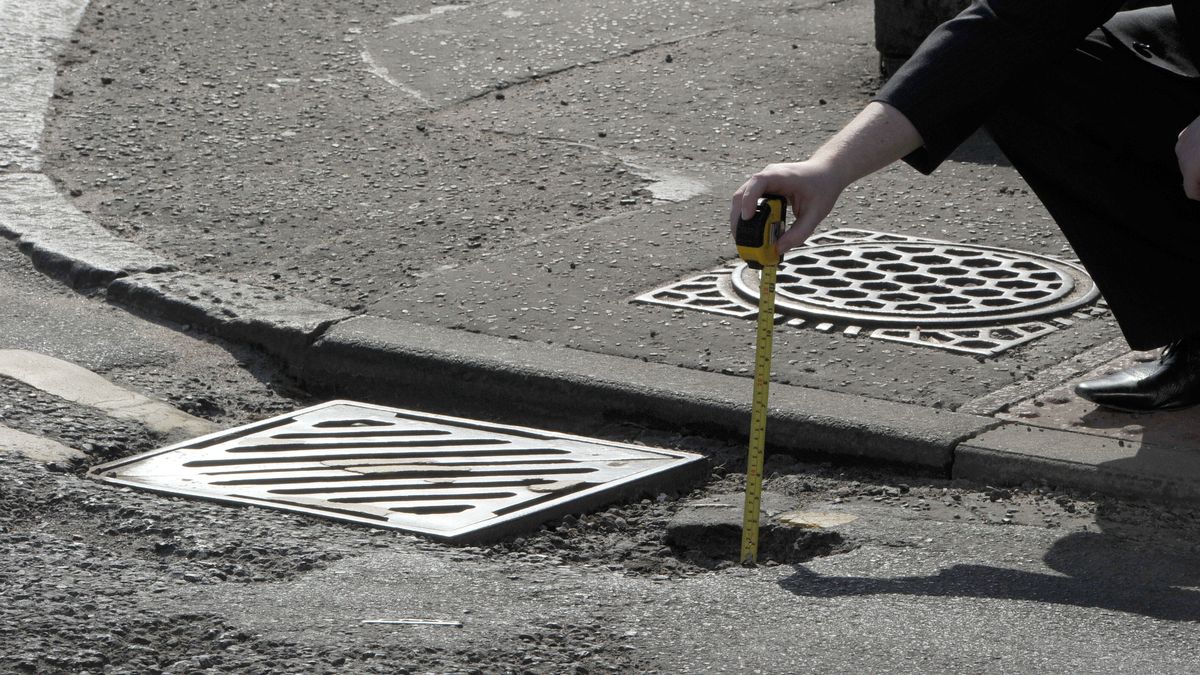 A pothole formed next to a gully grating