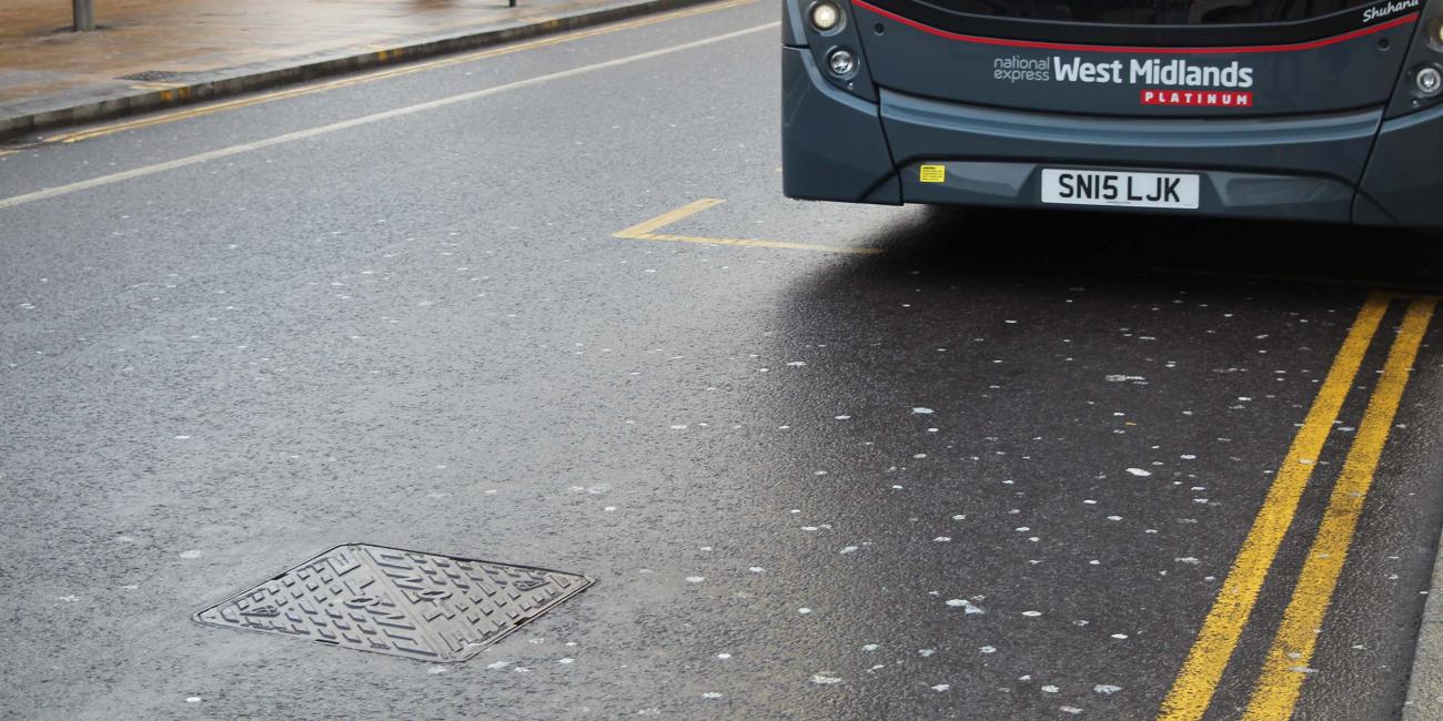 Unite manhole cover installed at a bus stop
