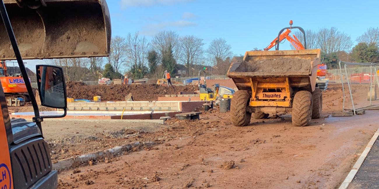 Typical site machinery during construction and cleaning of road surface with bucket