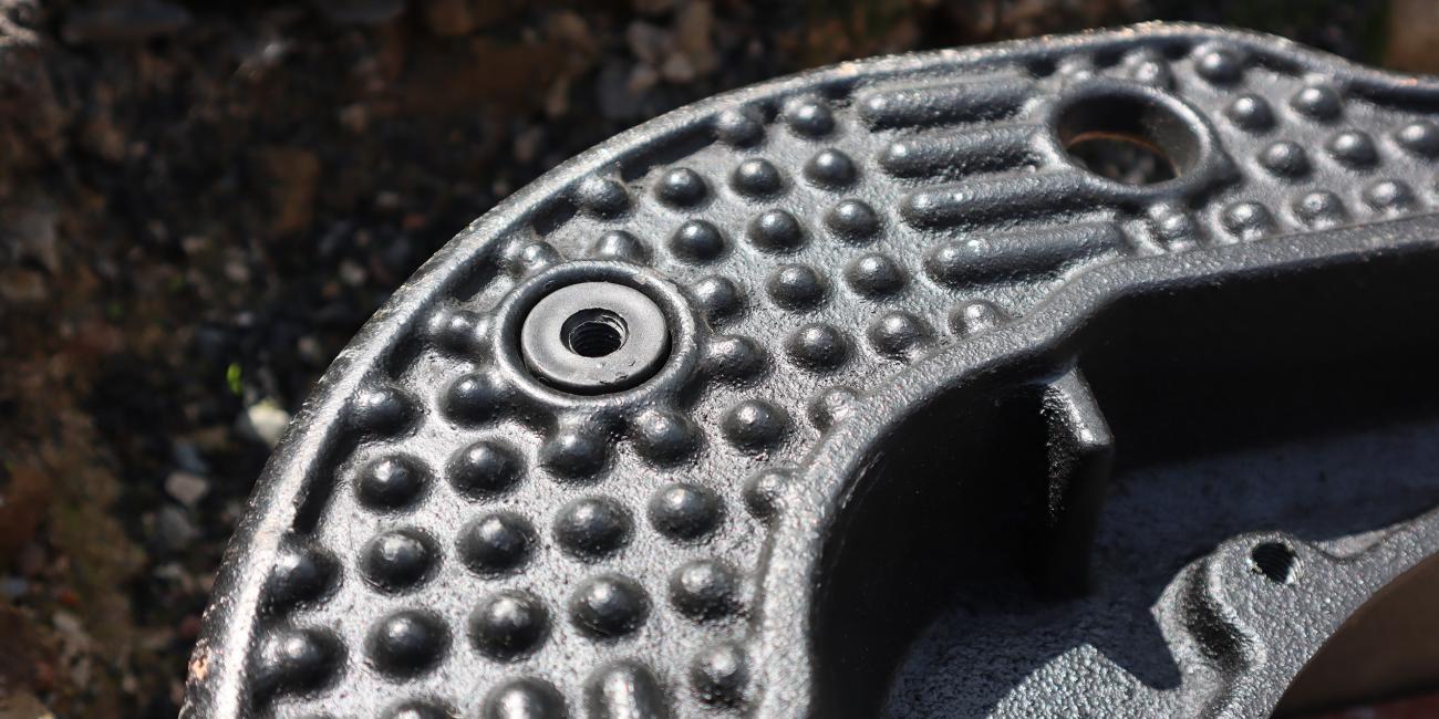 Screwlift inserted into underside of manhole cover frame