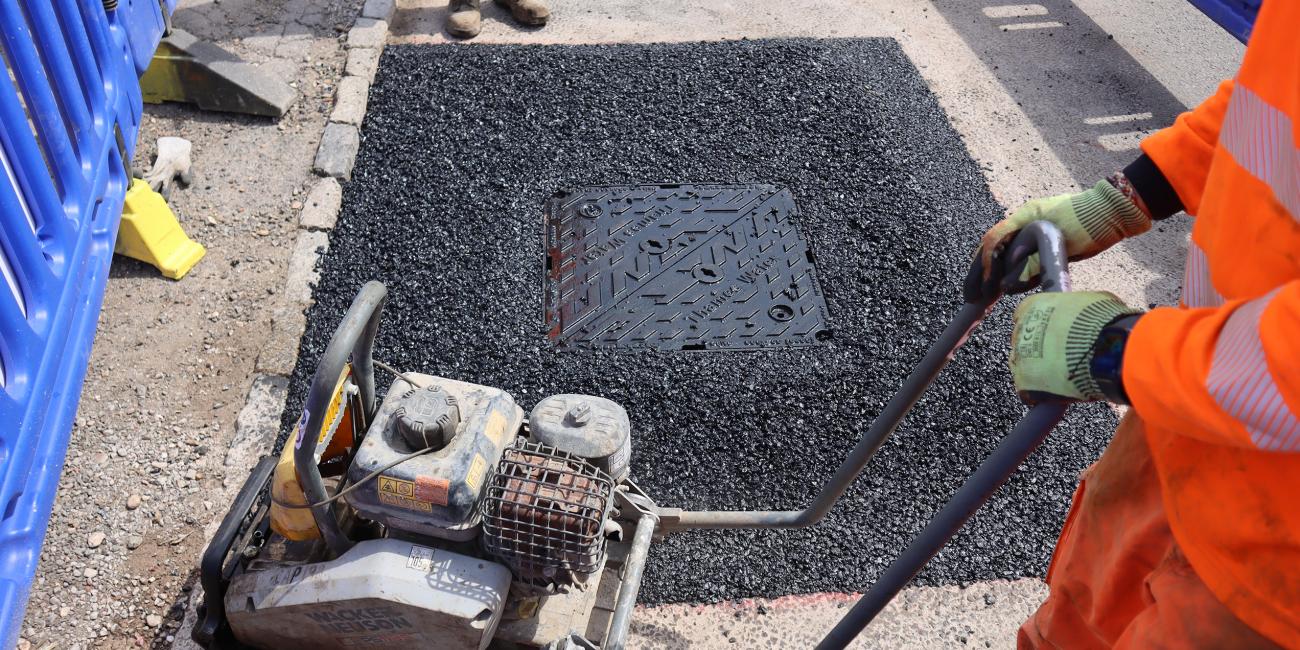 Final compaction around a Unite manhole cover to level road surface