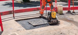 A man using a compactor to complete the installation of a Wrekin Unite manhole cover
