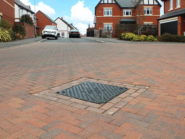 Highway manhole cover installed in road on newbuild housing estate