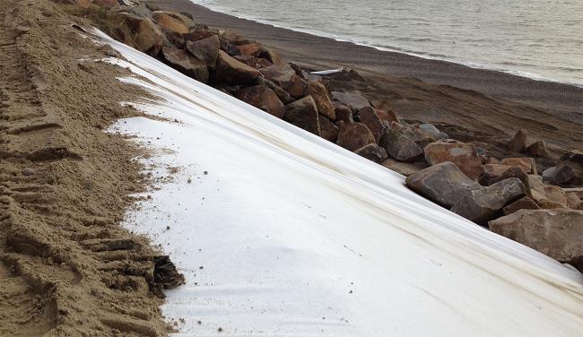Non woven geotextiles being installed along coast