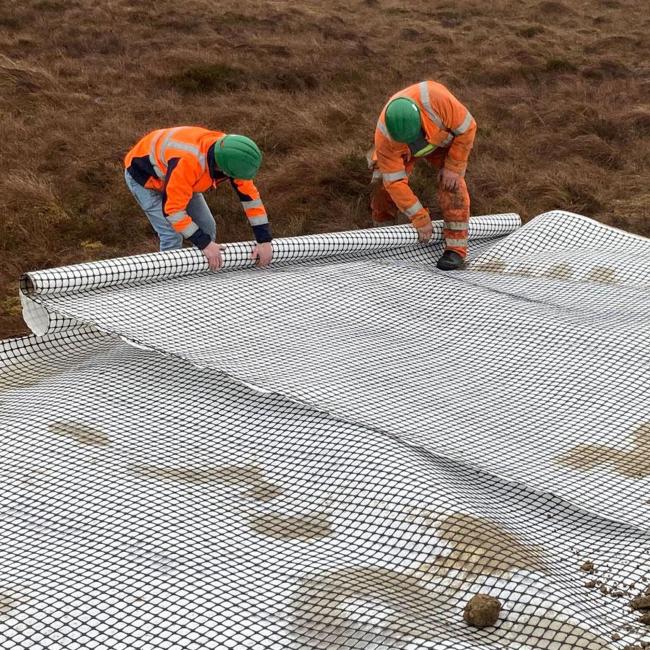 Geocomposite being installed by two people