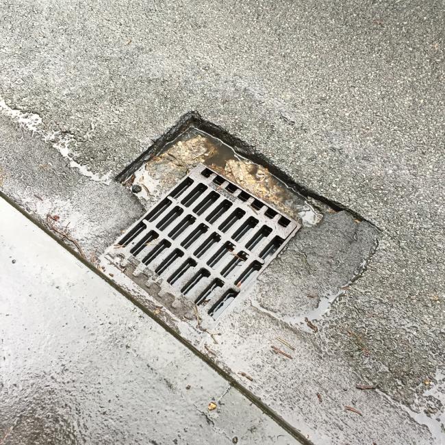 The breakup of the surround causing a pothole next to ironwork